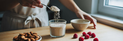 Scooping vegan protein powder into glass.