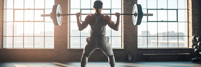 Vegan athlete lifting weights in gym.