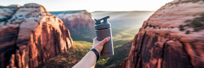 Person with protein shake at scenic overlook.