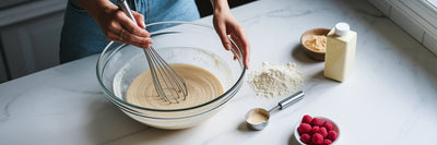 Whisking vegan protein pancake batter in kitchen.