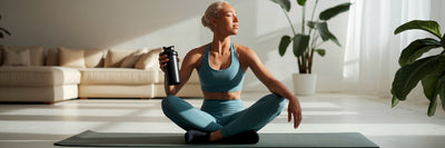 Person relaxing with protein shake post-workout.