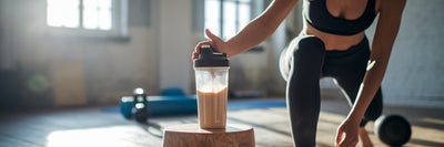 Person reaching for post-workout protein shake.