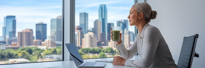 Professional enjoying protein smoothie at desk.