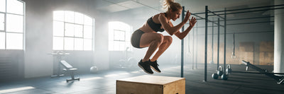 Vegan athlete performing a box jump.