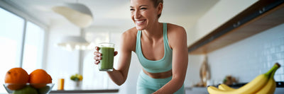 Active woman smiling with green smoothie.