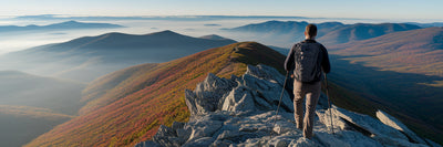 Hiker at mountain summit at sunrise.