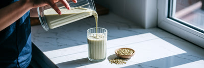 Person pouring a vegan protein shake in kitchen.