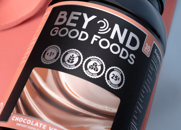 Beyond Good Foods chocolate vegan protein powder on a pink background
