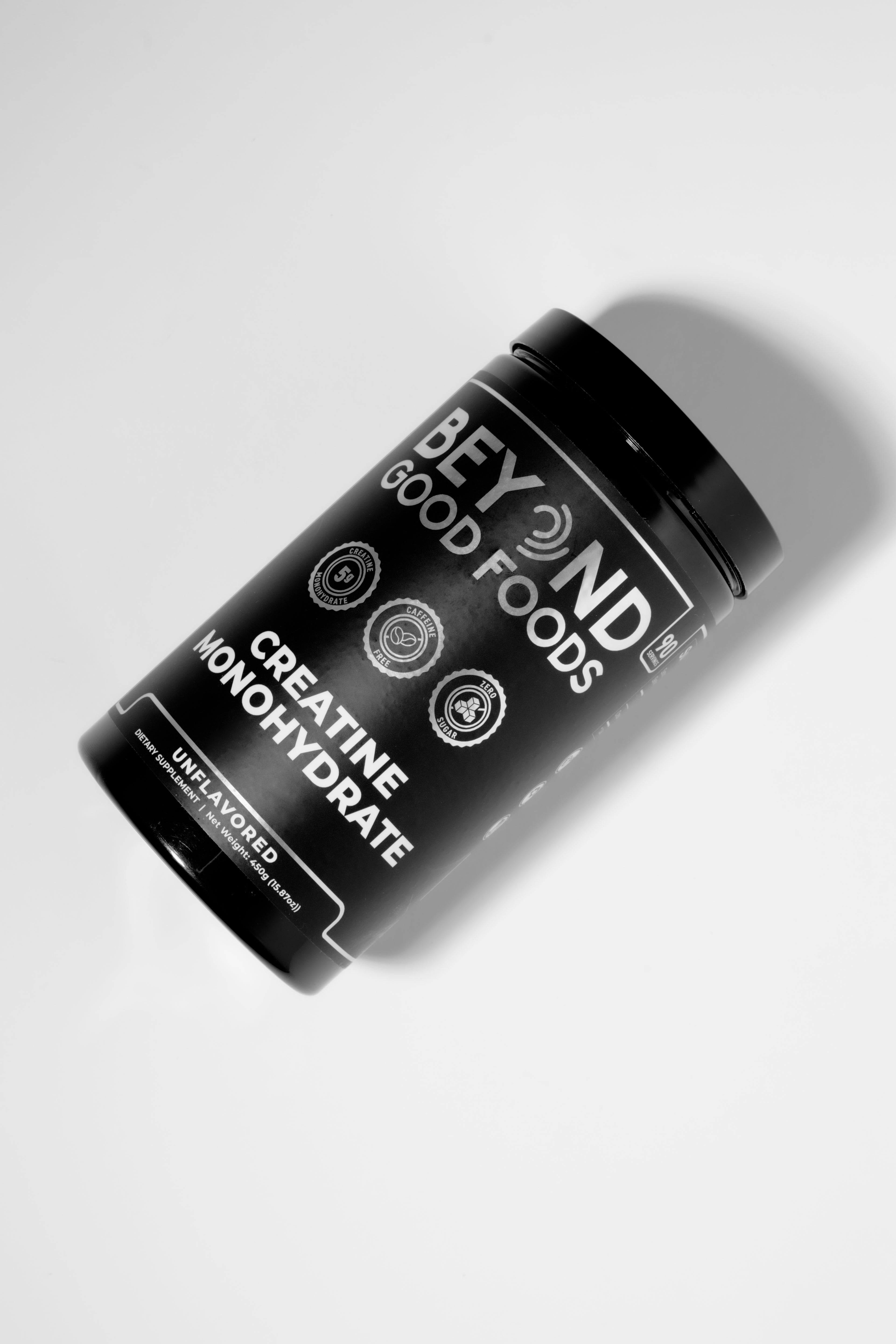 Black Creatine Monohydrate container labeled Beyond Good Foods on a white background